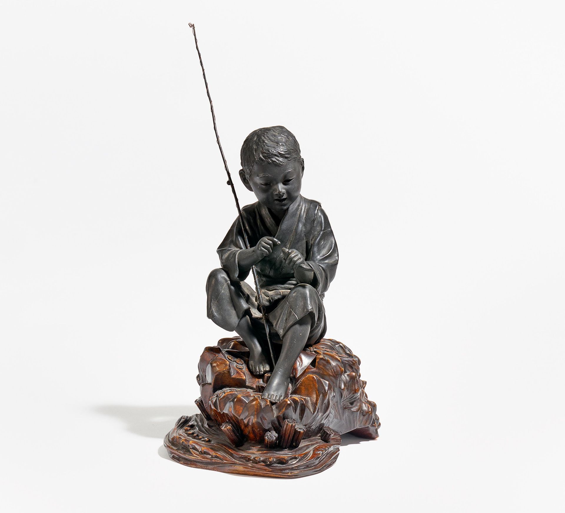 KNABE MIT FISCH UND ANGEL. Japan. Meiji-Zeit. Bronze mit dunkler Patina. Passender Sockel aus Holz - Bild 2 aus 4