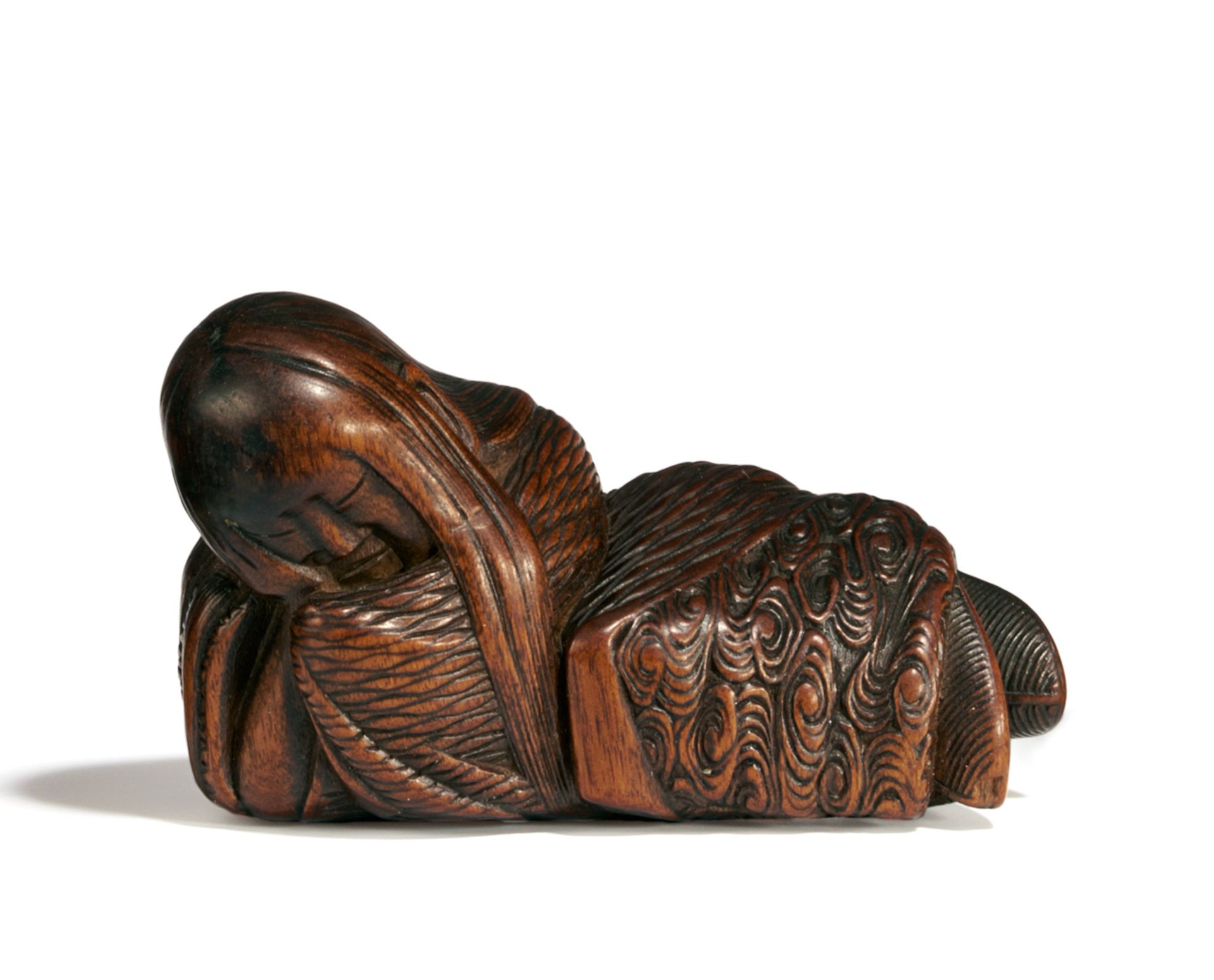 NETSUKE: SCHLAFENDER SHÔJÔ. Japan. Edo-Zeit. 19. Jh. Buchsbaum, dunkel eingefärbt, teils berieben.