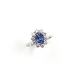 18 krt. witgouden entourage ring bezet met 1 blauwe saffier van circa 1.59 karaat omringd door 10