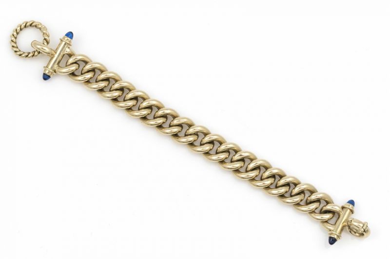 18 krt. gouden schakelarmband, aan de uiteinden bezet met blauwe saffieren, lengte: 19,5 cm.,
