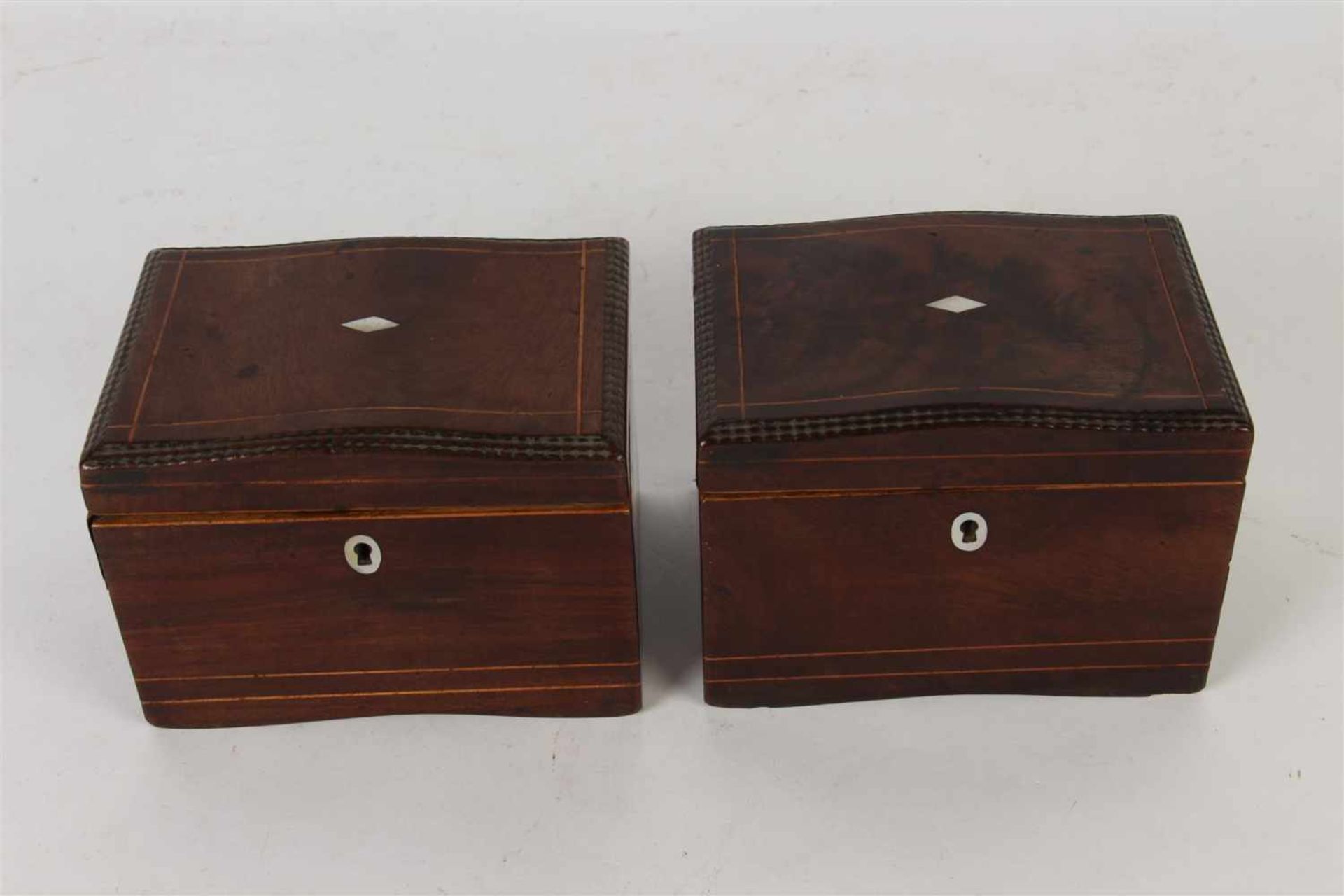 Twee mahoniehouten theekistjes met parelmoer inleg (met defect). Afm: 11 x 15 x 10.8 cm.