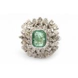 A white gold ring. Set with a light green emerald cut emerald and diamonds. Emerald ca. 0.90 ct.