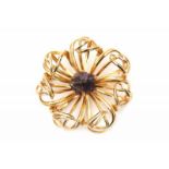 Costume jewellery - A brooch in the shape of a stylised flower with an amethyst crystal in the