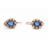 A pair of 14 krt rose gold earrings. Set with a drop shaped cabochon cut blue paste with an