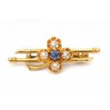 A 14 krt yellow gold clover shaped brooch. Set with old cut diamond and synthetic sapphire. Lengte