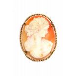 A shell cameo depiciting a classical woman, a bacchante. In a yellow gold mount. 19th century.