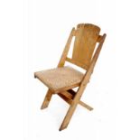 An oak folding chair with cane seat (some damage), circa 1930. 88,5 cm. h. 29.00 % buyer's premium