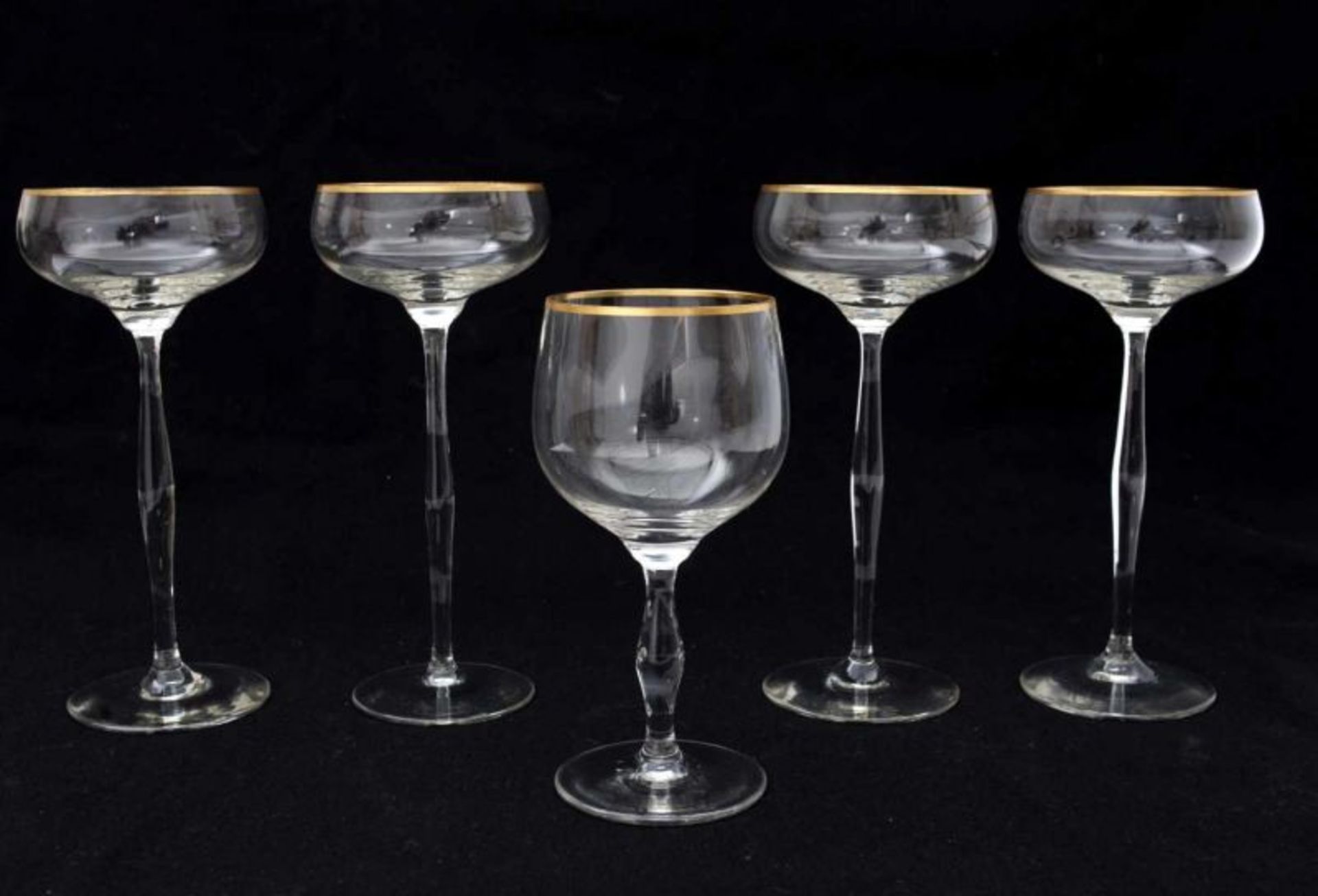 Hans Christiansen (1866-1945) Four champagne glasses on high stem and a wine glass, all with gilt