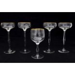 Hans Christiansen (1866-1945) Four champagne glasses on high stem and a wine glass, all with gilt