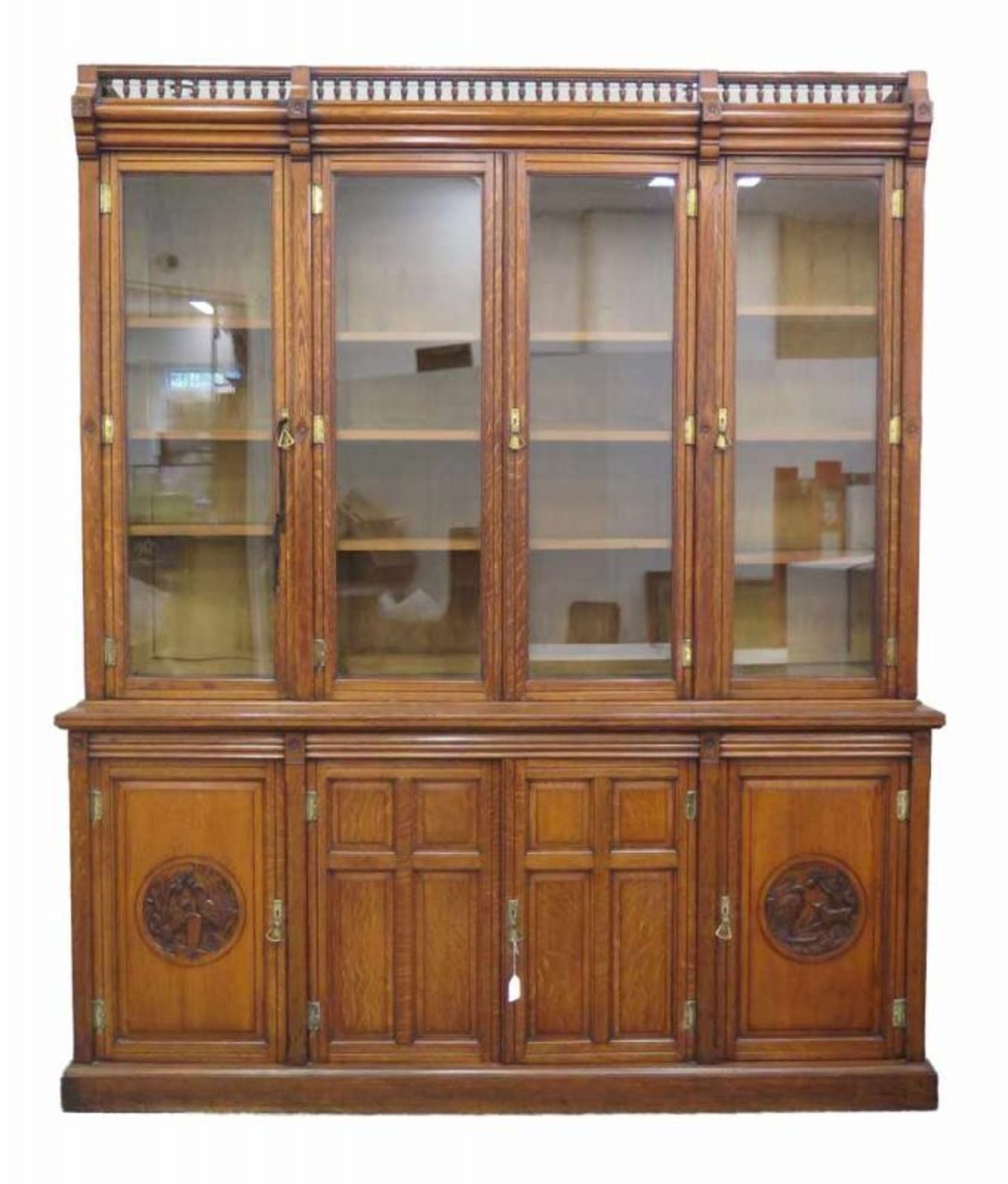 James Winter & Sons, Soho, London An oak bookcase, the lower part with four doors of which two with