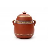 In the style of Christopher Dresser (1834-1904)A red stoneware lidded jar with two handles,