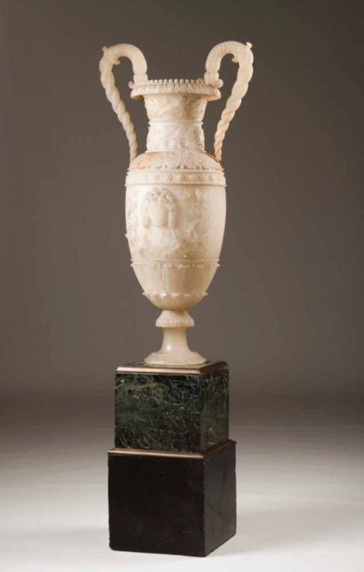 A pair of large urns Carved alabaster with vine leaves, grapes and other floral motifs Marble bases