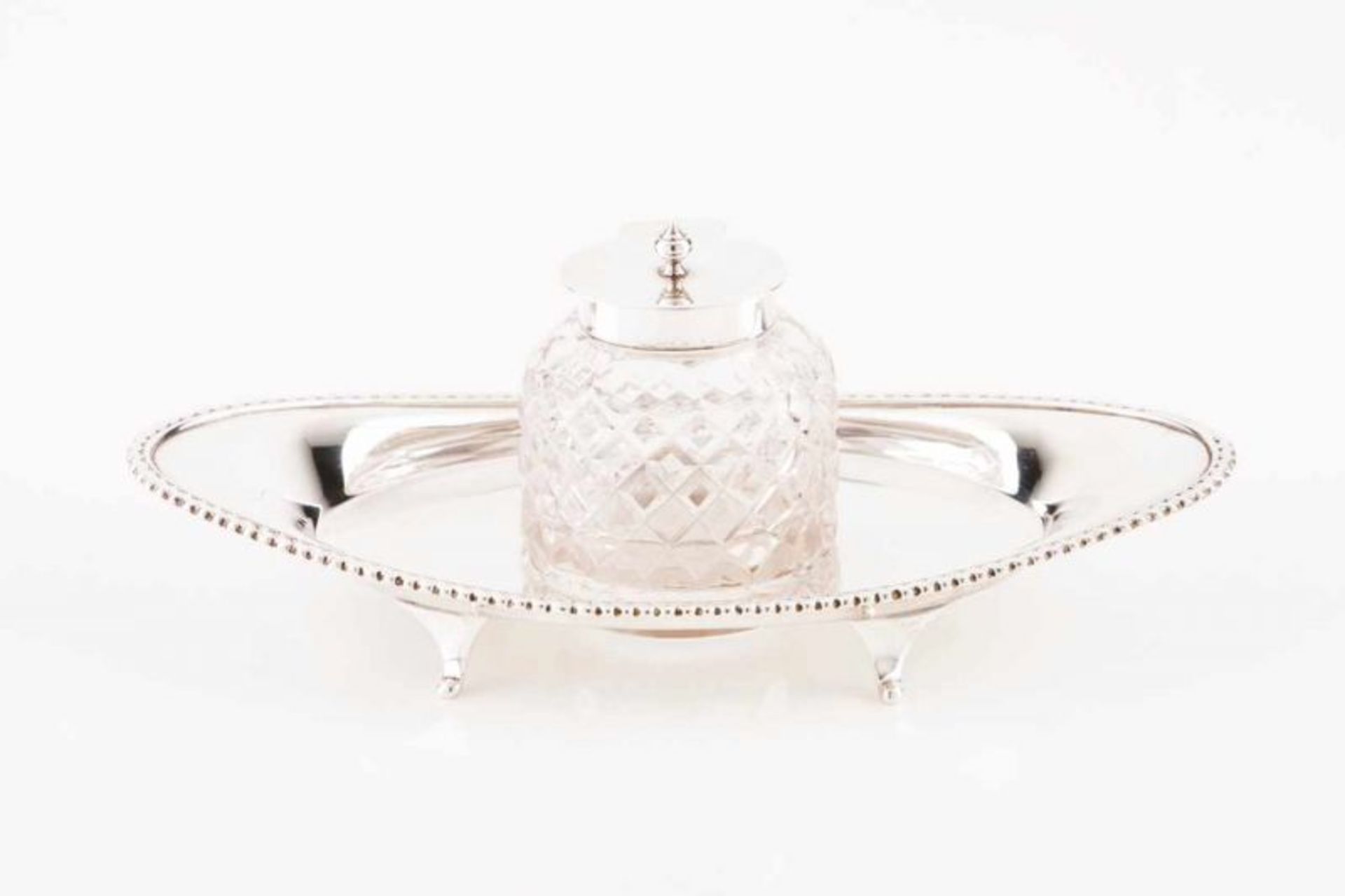 An inkpot English silver Oval tray raised on four feet, cut-crystal inkpot with silver cover Faded