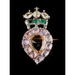 A brooch Designed as a crowned heart, set in silver with one pear-shaped orange topaz, three green