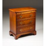 A small George II style commode Walnut and burr-walnut One brushing slide and three drawers Brass