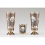 A pair of Russian cups Gilt silver with profuse engraved and niello decoration with scrolls, views