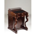 A Victorian Davenport Mahogany Top with gallery and leather lined writing surface Serpentine front