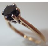 Black diamond solitaire ring in a white gold setting on a yellow gold shank size N approximately 0.