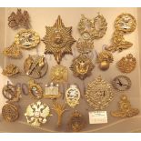 Twenty five military cap badges