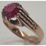 Large circular cut faceted ruby on an unusual yellow metal ring ruby approximately 1.5ct size U 5.