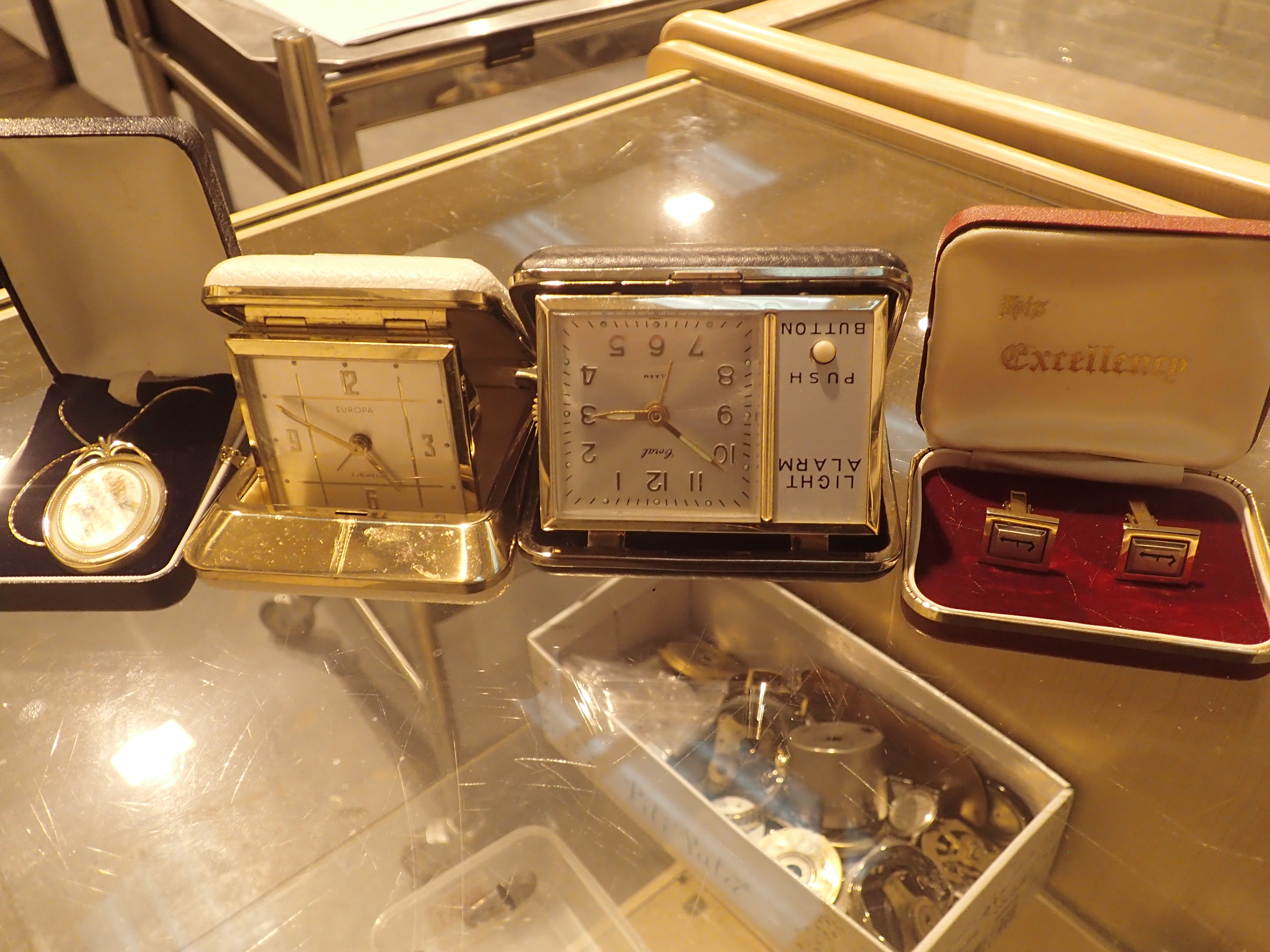 Two mechanical travelling alarm clocks a box of cufflinks and a boxed pendant