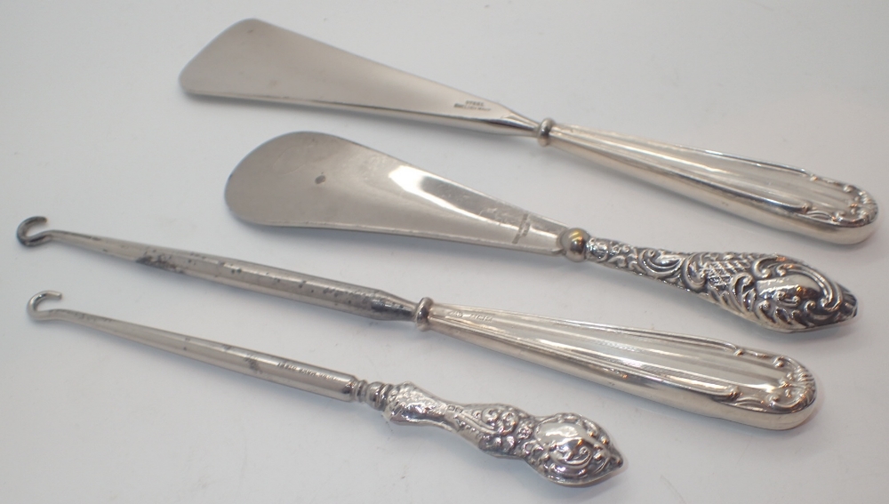 Two pairs of silver handled button hooks and shoe horns