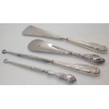 Two pairs of silver handled button hooks and shoe horns