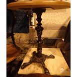 Set of three matching cast iron single pedestal four footed pub tables with non matching wooden
