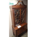 Edwardian mahogany bookcase with twin astragal glazed doors and pierced pediment above cupboard