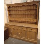 Large pine dresser with four drawers over four cupboards with plate rack containing six drawers 182