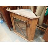 Pine corner cupboard with glass front and shaped inner shelf