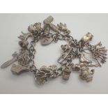 Hallmarked silver charm bracelet with eighteen charms and a padlock clasp