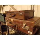 Two antique leather suitcase with some travel labels