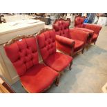 Two red upholstered armchairs with carved wooden frames with two matching low chairs