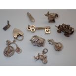 Nine various silver charms and a silver