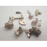 Nine various silver charms and a silver padlock clasp