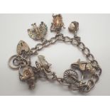 Hallmarked silver bracelet with padlock clasp and seven charms