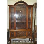 An Edwardian mahogany display cabinet witharched top over an astragal glazed door with panelled door