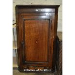 A George III oak and mahogany hanging corner cupboard, 123cm high.