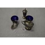 A silver cruet set comprising pair of salts, mustard pot and pepperette, all with glass liners,