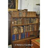 An Edwardian oak open bookcase with adjustable shelves over a pair of cupboard doors, 106.5cm wide.