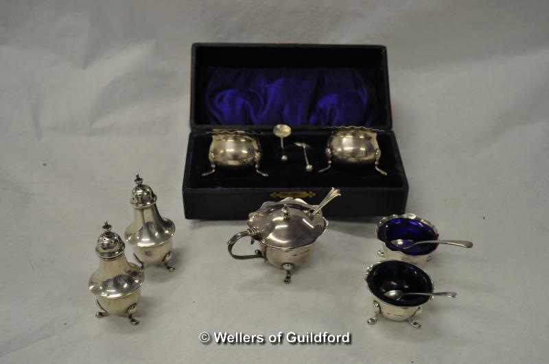 A silver cruet se tcomprising pair of pepperettes, pair of salts and a mustard pot with three odd