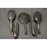 A silver dressing table set comprising hand mirror, two hair brushes and two hat brushes, Chester