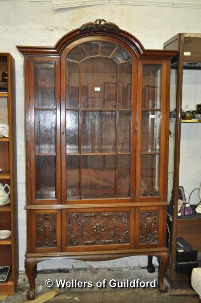 An Edwardian mahogany display cabinet witharched top over an astragal glazed door with panelled door