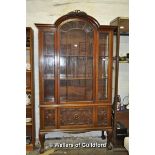 An Edwardian mahogany display cabinet witharched top over an astragal glazed door with panelled door