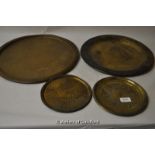 Four brass chargers and plates