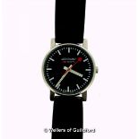 *Mondaine wristwatch, circular black dial, with white baton hour markers, on a black leather