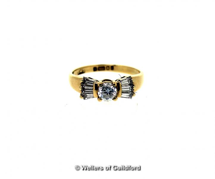 Diamond set ring, central round brilliant cut diamond with three tapered baguette cut diamonds to