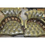 A pair of modern green leather swivel desk chairs.