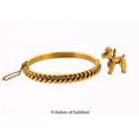 Hinged bangle with a plait design, in yellow metal stamped 10ct, together with a 9ct gold dog charm,